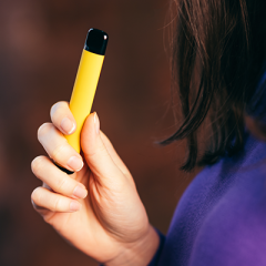 Woman holding yellow vape
